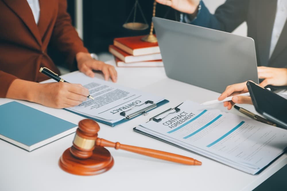 A businessman and a lawyer discuss a legal contract, reviewing the terms before signing a business agreement.