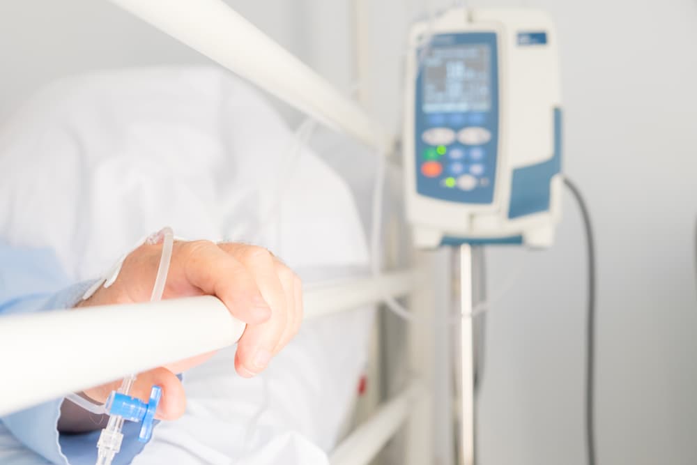 Hand of senior person in a hospital bed