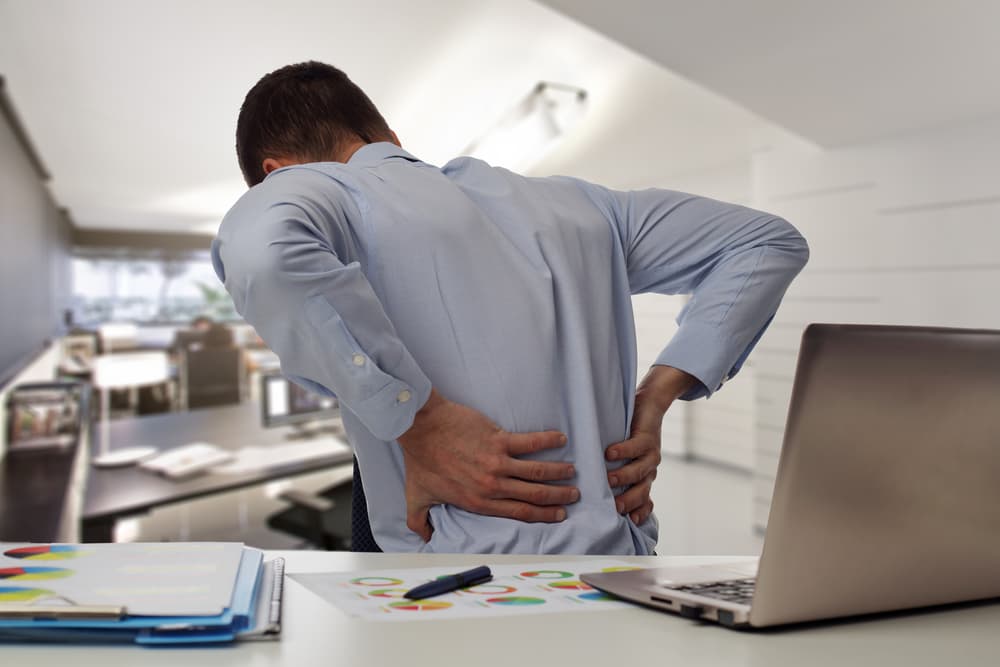 An employee with back pain an office